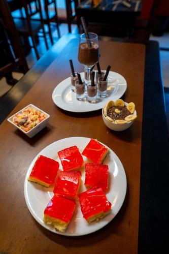 two plates of food on a wooden table at London Eye Hotel Nuwaraeliya in Nuwara Eliya