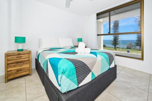 a bedroom with a bed and a window at Alex Heads Beachfront Bliss in Alexandra Headland