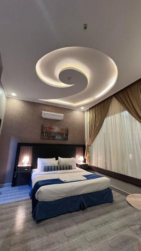 a large bedroom with a large bed with a ceiling at شاليهات بالي in Baljurashi