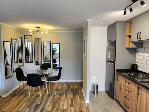eine Küche und ein Esszimmer mit Tisch und Stühlen in der Unterkunft Moderno y céntrico departamento in Los Andes