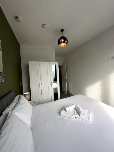 a bedroom with a large white bed with towels on it at Abbey Apartments in Dublin