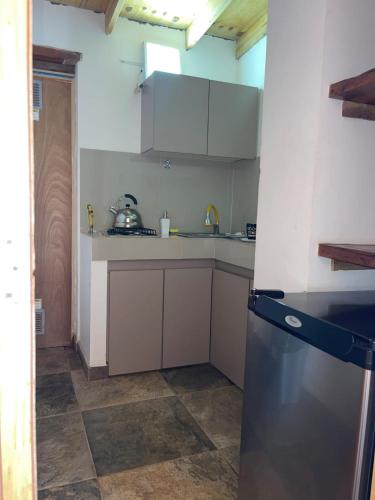 a kitchen with a black refrigerator in a room at Hotel La Cochera in San Pedro de Atacama