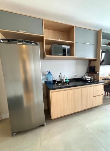 a kitchen with a stainless steel refrigerator and cabinets at Flat Mirant Vila Madalena in São Paulo