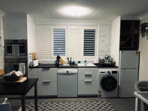 a kitchen with a sink and a refrigerator at Luxury Boutique Self-Contained Private Granny Flat in Ormeau
