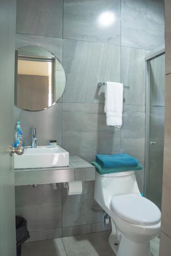 a bathroom with a toilet and a sink and a mirror at condominio con una bonita vista del puerto deportivo de G P S rentas in Mazatlán