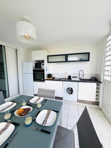a kitchen with a table with plates of food on it at Bleu Lagon - Vue mer, Piscine, Marina et Golf in Saint-François