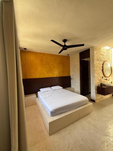 a bedroom with a bed with a ceiling fan at Casona La Jacinta in Sisal