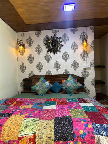 a bedroom with a bed with a colorful quilt on it at Laxmi Narayan Homestay-Harshil in Harsil