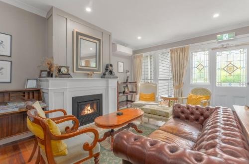 a living room with a couch and a fireplace at The Bundanoon Guest House in Bundanoon