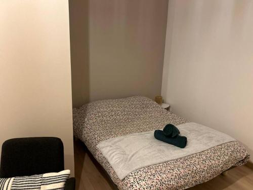 a room with a bed with a black hat on it at Studio - Proche Centrex & Disneyland in Noisy-le-Grand