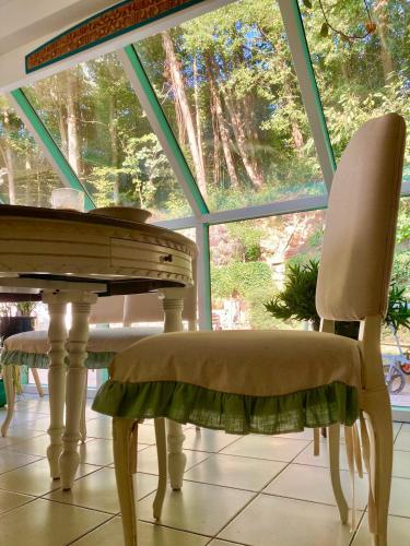 a table and chairs in a room with a large window at Family home, green surroundings, 10 min from Brussels in Overijse