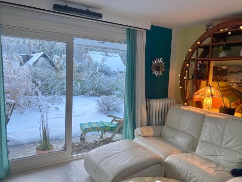 a living room with a couch and a sliding glass door at Family home, green surroundings, 10 min from Brussels in Overijse