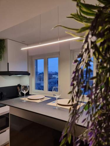 - une cuisine avec 2 verres à vin sur un comptoir dans l'établissement Sur la savoureuse - Le 31, à Belfort