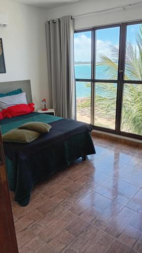 a bedroom with a bed and a view of the ocean at Xareu-Balanço das Ondas! in Cabo de Santo Agostinho