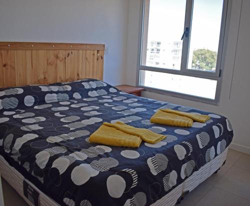 een slaapkamer met een bed met twee gele handdoeken erop bij Franca Austral in Puerto Madryn