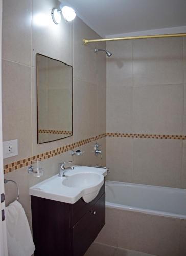 a bathroom with a sink and a mirror and a tub at Franca Austral in Puerto Madryn