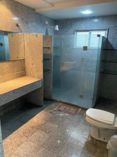 a bathroom with a toilet and a glass shower at Cobertura Duplex Próx da Praia in Recife