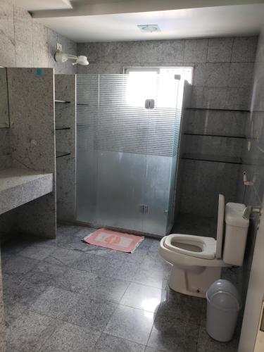 a bathroom with a toilet and a glass shower at Cobertura Duplex Próx da Praia in Recife