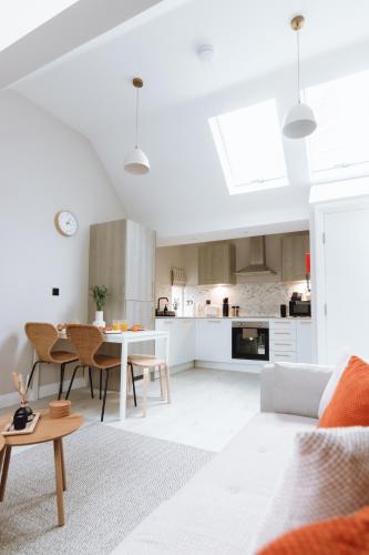 a kitchen and living room with a couch and a table at Luxury 2 BD with Free Parking & WIFI, Near Train Station and Stockport Hospital in Stockport
