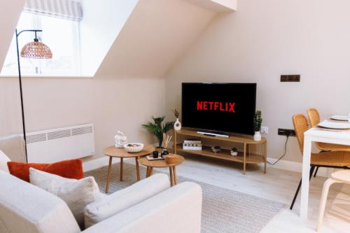 a living room with a white couch and a tv at Luxury 2 BD with Free Parking & WIFI, Near Train Station and Stockport Hospital in Stockport