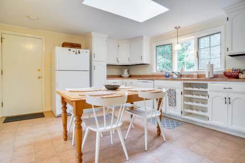 a kitchen with a wooden table and white appliances at Furnished Deck Retreat on Mashpee River! in Mashpee