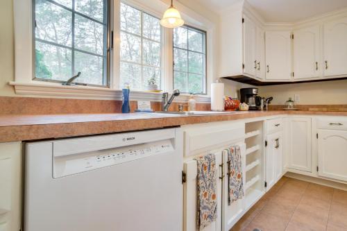 a kitchen with white cabinets and a sink at Furnished Deck Retreat on Mashpee River! in Mashpee