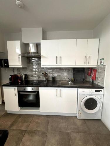 a kitchen with white cabinets and a sink and a dishwasher at Abbey Apartments in Dublin