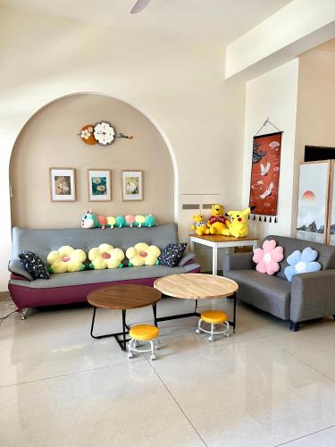 a waiting room with a couch and two tables at Daisy's Hsiang Hola in Chiayi City