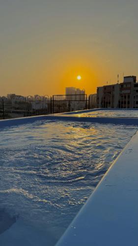a swimming pool with the sunset in the background at Hotel Caribe Plaza Barranquilla in Barranquilla