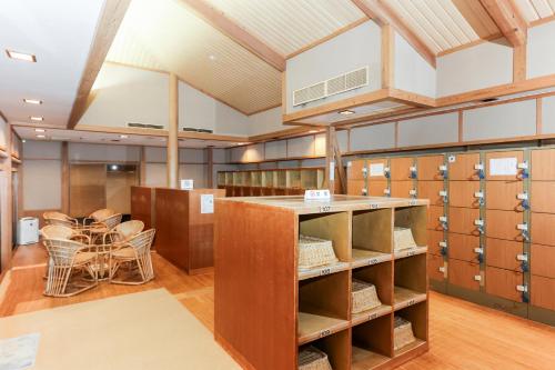 a large room with lockers and a table at Ichinomata Onsen Grand Hotel in Shimonoseki