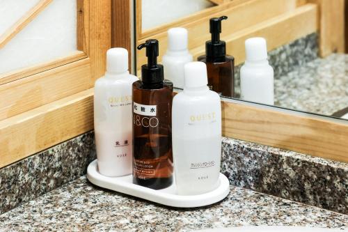 three bottles ofodorizers sitting on a counter in front of a mirror at Ichinomata Onsen Grand Hotel in Shimonoseki
