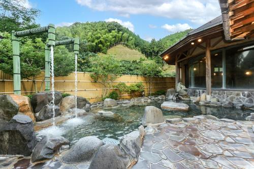 a pond with a waterfall in a yard at Ichinomata Onsen Grand Hotel in Shimonoseki