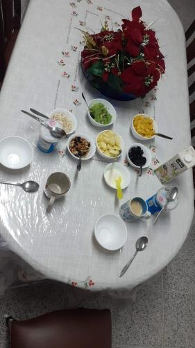 een witte tafel met borden en lepels erop bij Pérola Achadense Guesthouse in Achada