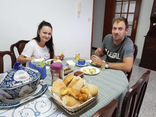 een man en vrouw aan een tafel met eten bij Pérola Achadense Guesthouse in Achada