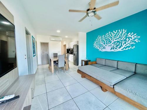 a living room with a couch and a blue wall at penthouse vista a 5min de la playa by G P S rentas in Mazatlán