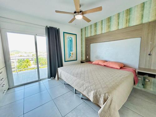 a bedroom with a bed and a ceiling fan at penthouse vista a 5min de la playa by G P S rentas in Mazatlán