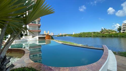 a swimming pool next to a body of water at penthouse vista a 5min de la playa by G P S rentas in Mazatlán