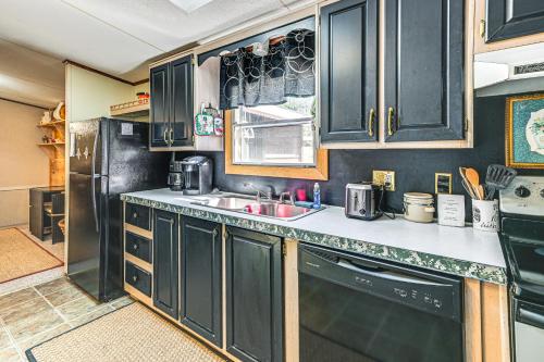 a kitchen with black cabinets and a sink at Fire Pit and Decks Creekside Cabin in Robbinsville in Robbinsville