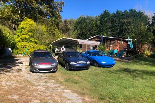 a group of three cars parked in a yard at Fire Pit and Decks Creekside Cabin in Robbinsville in Robbinsville