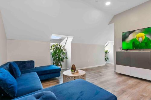 a living room with a blue couch and a tv at Stylish Comfort Wooster Square Yale Wi-Fi in New Haven