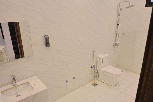 a white bathroom with a toilet and a sink at شاليهات جوري in Jeddah
