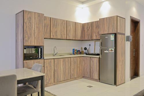 a kitchen with wooden cabinets and a stainless steel refrigerator at شاليهات جوري in Jeddah