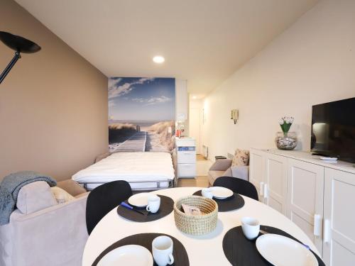 a living room with a couch and a table at Apartment near Belgian Coast Beach in Oostduinkerke