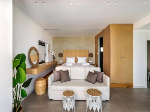 a bedroom with a white bed and two stools at Villa in Gournes with Private Pool & Sea Views in Heraklion