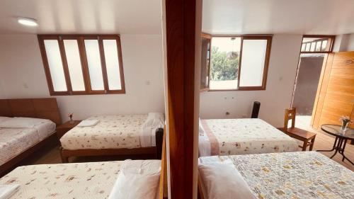 a bedroom with two beds and two windows at HOTEL HACIENDA SUBTANJALLA CASABLANCA in El Cambio