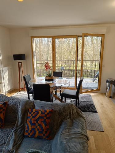 un salon avec une table et des chaises et une salle à manger dans l'établissement Chez Sibylle ParcNaturelPetitVeniseChevreuseVersaillesOrly appartement entier 69 M2 ou chambre, à Saint-Rémy-lès-Chevreuse