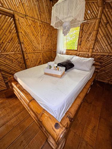 a bed in a thatched room with a tray on it at Pueblo Chiquito in Inderena
