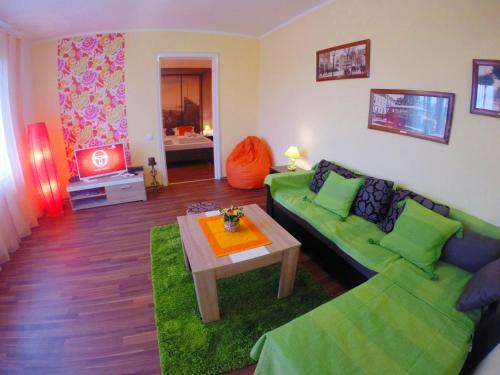 a living room with a green couch and a table at Balkan-inn Skadarlija 2 apartment in Belgrade