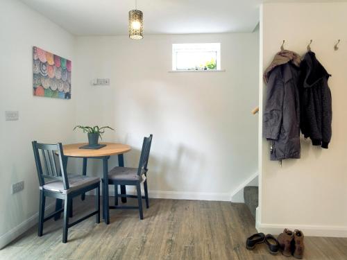 une salle à manger avec une table et deux chaises dans l'établissement Coley Cottage, à Wainfleet All Saints