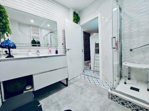 a white bathroom with a sink and a shower at Apartamento in Donostia-San Sebastián